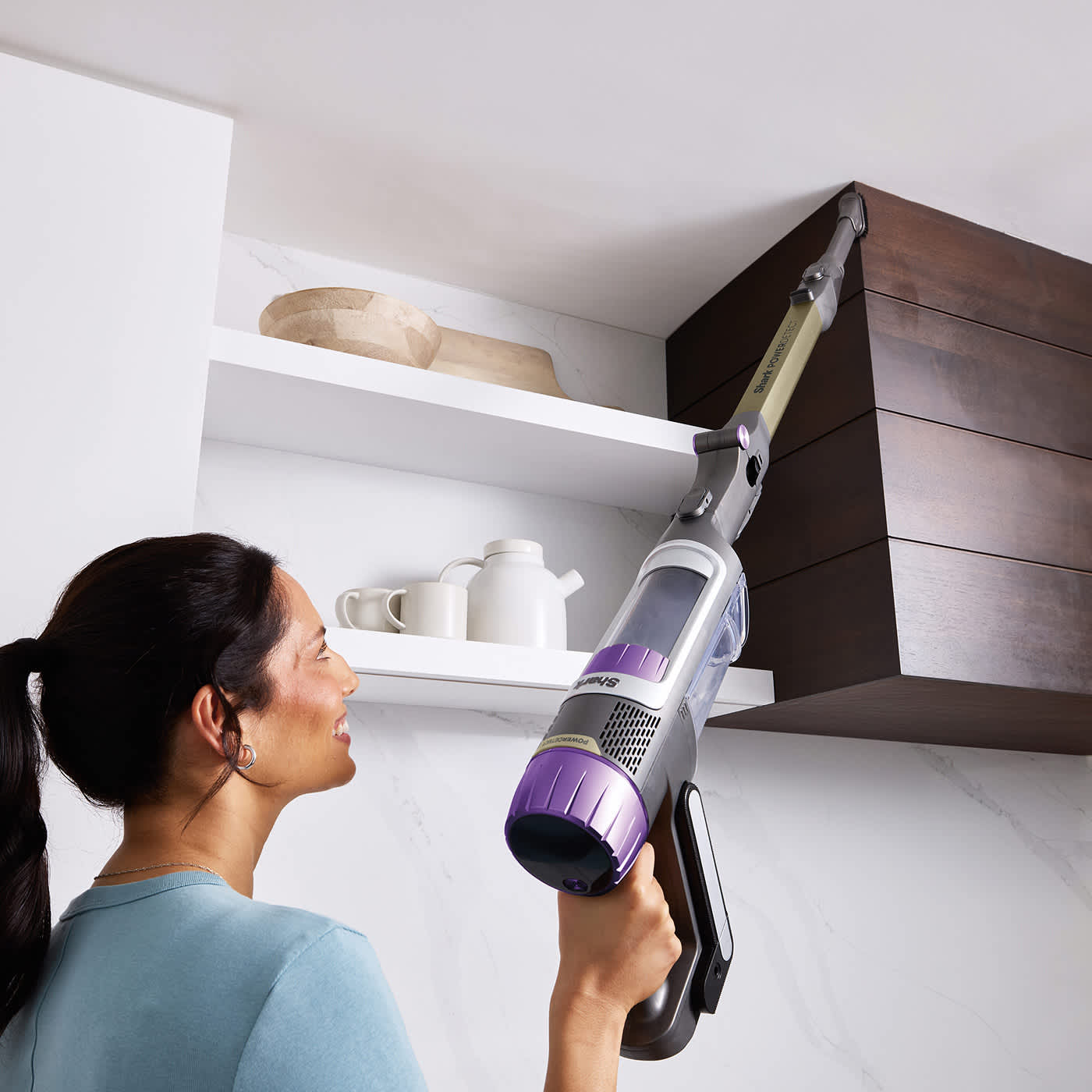 Woman cleaning the kitchen using the Shark PowerDetect cordless vacuum